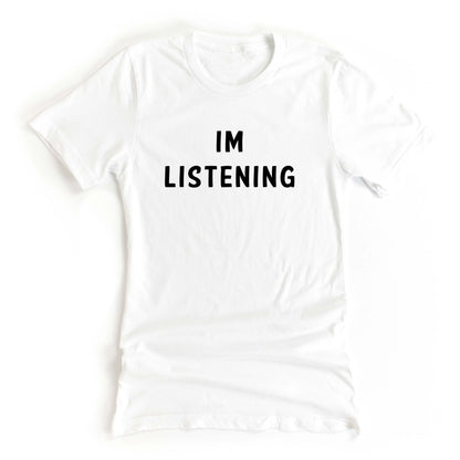 White tshirt on a white background with the text Im Listening in black ink 