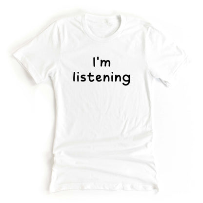 White tshirt on a white background with the text Im Listening in black ink 